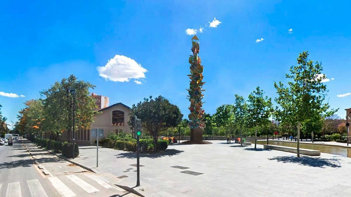 Imagen ilustrativa: escultura abstracta de gran tamaño en un parque urbano, con luz de atardecer y edificios al fondo.