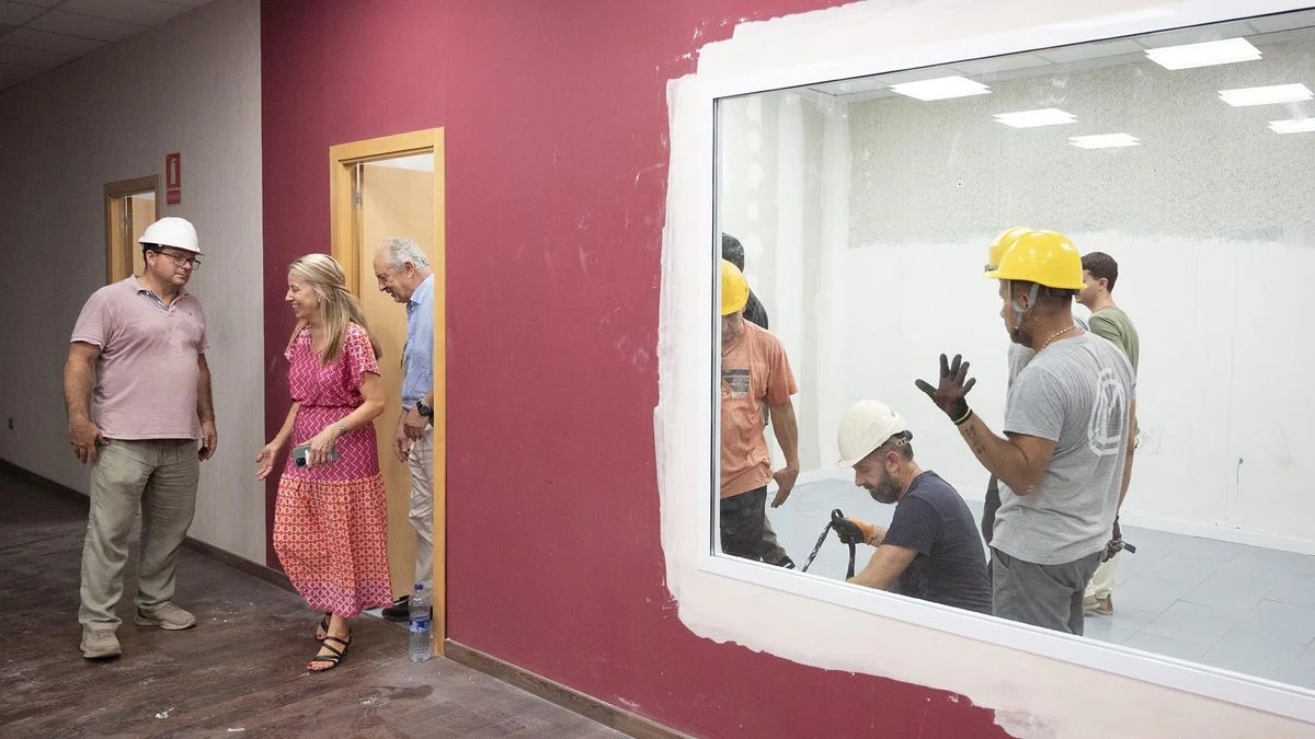 Imagen ilustrativa: interior de una sala comunitaria renovada, con paneles acústicos en el techo y sillas apiladas.