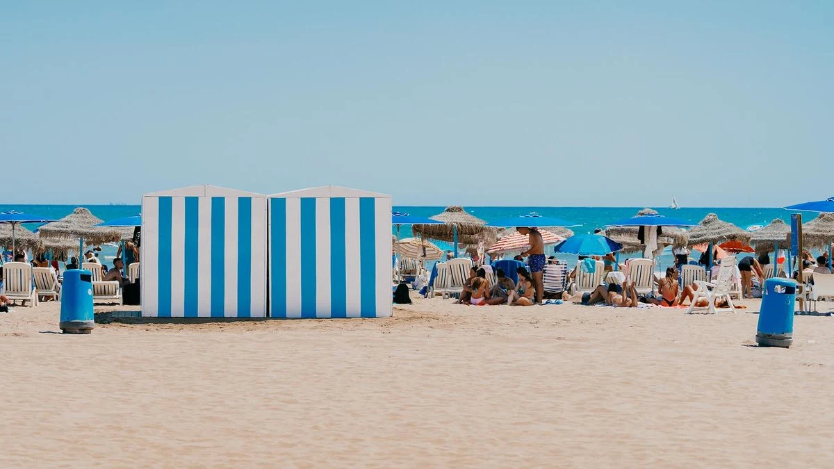 Imagen ilustrativa: una torre de vigilancia y un flotador naranja en la arena de una playa, con el mar al fondo.