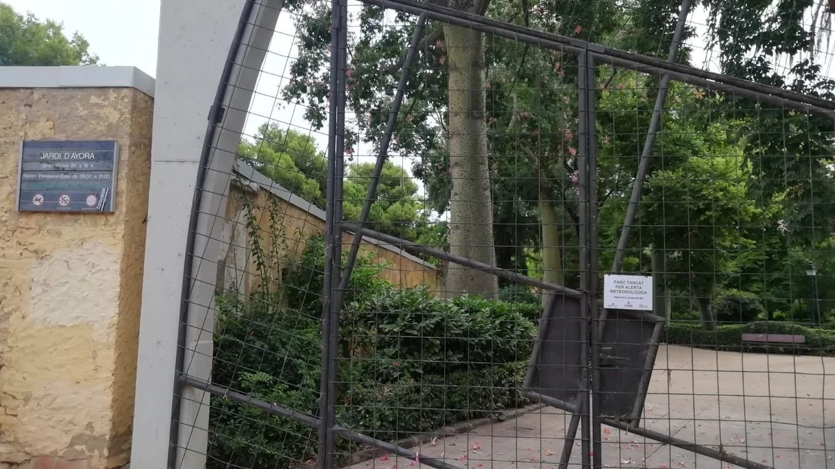 Imagen ilustrativa: un parque urbano con verjas cerradas y cielo nublado, con bancos y fuente al fondo