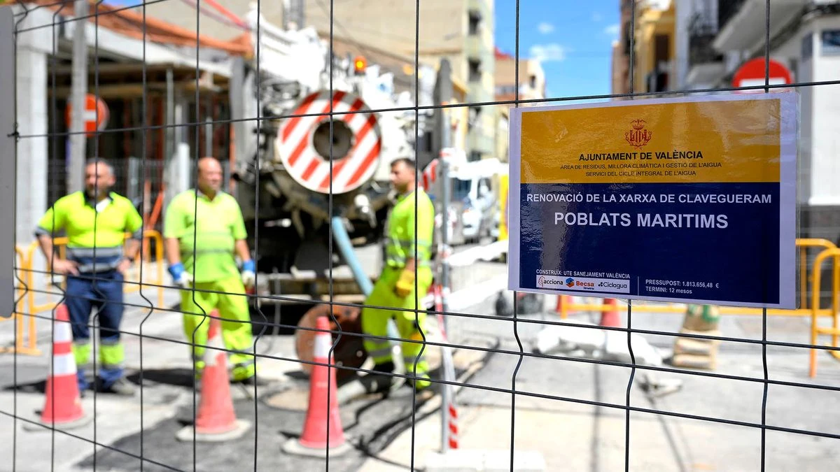 Imagen ilustrativa: obras de saneamiento en una calle de un barrio residencial con zanja y vallas de obra